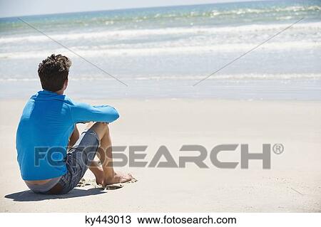 Man sitting on the beach View Large Photo Image Stock Image - Man sitting on the beach. Fotosearch