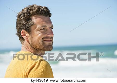 Man smiling on the beach View Large Photo Image Stock Photo - Man smiling on the beach. Fotosearch