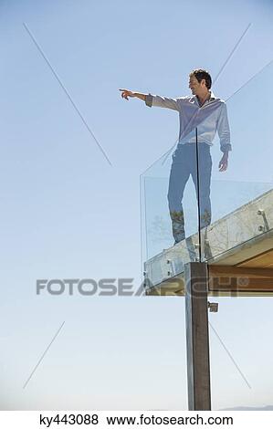 Man standing on the terrace and pointing View Large Photo Image Stock Photo - Man standing on the terrace and pointing. Fotosearch