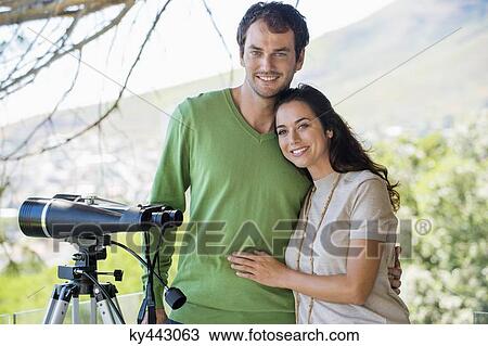 Portrait of a couple smiling beside a binoculars on tripod View Large Photo Image Stock Image - Portrait of a couple smiling beside a binoculars on tripod. Fotosearch