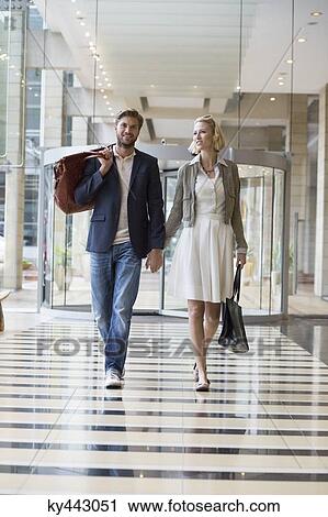 Smiling couple walking at an airport View Large Photo Image Stock Image - Smiling couple walking at an airport. Fotosearch