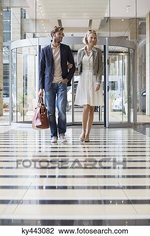 Stock Image - Smiling couple walking at an airport. Fotosearch