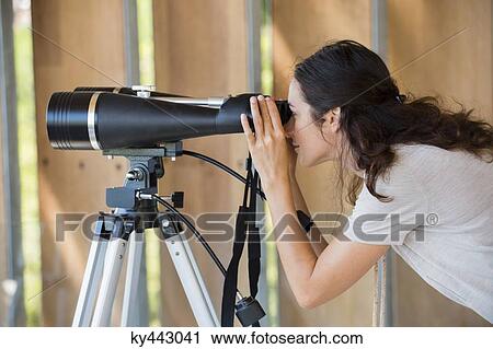 Woman looking through binoculars on tripod View Large Photo Image Stock Image - Woman looking through binoculars on tripod. Fotosearch