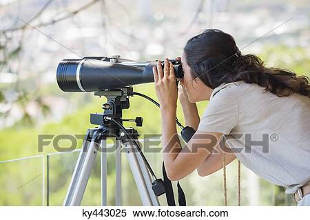 Woman looking through binoculars on tripod View Large Photo Image Stock Photography - Woman looking through binoculars on tripod. Fotosearch