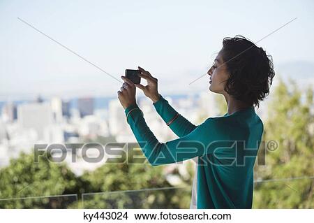 Woman photographing with a mobile phone View Large Photo Image Picture - Woman photographing with a mobile phone. Fotosearch