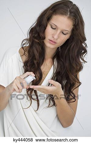 Close-up of a woman holding a hair conditioner View Large Photo Image Stock Photo - Close-up of a woman holding a hair conditioner. Fotosearch
