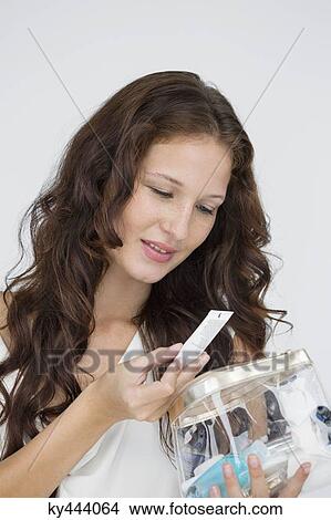 Close-up of a woman holding a make-up bag and smiling View Large Photo Image Picture - Close-up of a woman holding a make-up bag and smiling. Fotosearch