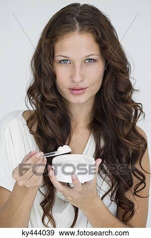 Portrait of a woman holding moisturizer cream View Large Photo Image Stock Photo - Portrait of a woman holding moisturizer cream. Fotosearch