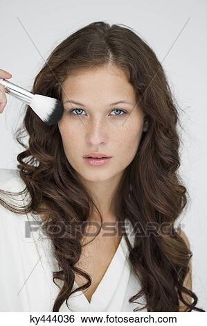Portrait of a woman using make-up brush on face View Large Photo Image Stock Photograph - Portrait of a woman using make-up brush on face. Fotosearch