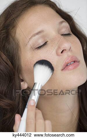 Woman doing make-up with a make-up brush View Large Photo Image Stock Image - Woman doing make-up with a make-up brush. Fotosearch