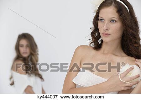 Woman holding a flower sponge with her friend in the background View Large Photo Image Stock Photo - Woman holding a flower sponge with her friend in the background. Fotosearch
