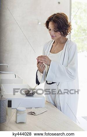Woman mixing hair dye in a bathroom View Large Photo Image Stock Photo - Woman mixing hair dye in a bathroom. Fotosearch