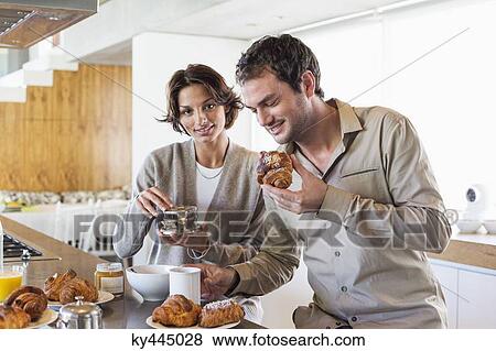 Couple having breakfast at a kitchen counter View Large Photo Image Stock Photo - Couple having breakfast at a kitchen counter. Fotosearch