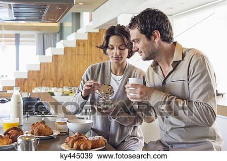 Couple having breakfast at a kitchen counter View Large Photo Image Stock Photo - Couple having breakfast at a kitchen counter. Fotosearch
