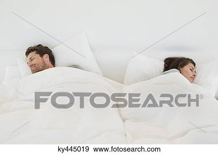 Stock Photo - Couple sleeping on the bed. Fotosearch