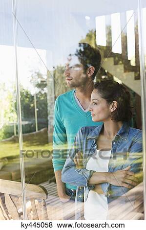 Stock Photo - Couple standing behind a glass wall. Fotosearch
