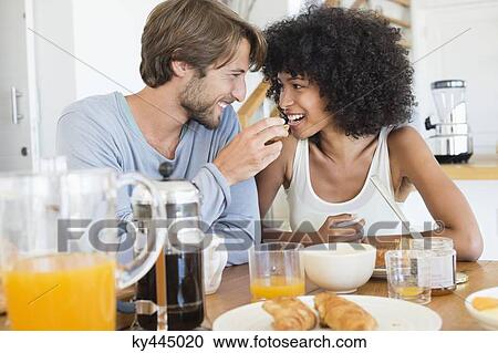 Stock Image - Man feeding food to her wife. Fotosearch