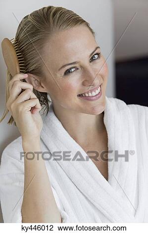 Portrait of a smiling woman brushing her hair View Large Photo Image Stock Image - Portrait of a smiling woman brushing her hair. Fotosearch