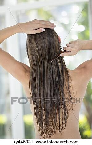 Rear view of a woman combing her hair View Large Photo Image Stock Image - Rear view of a woman combing her hair. Fotosearch