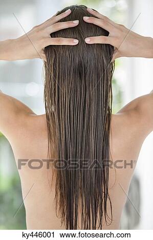 Stock Image - Woman massaging her hair. Fotosearch
