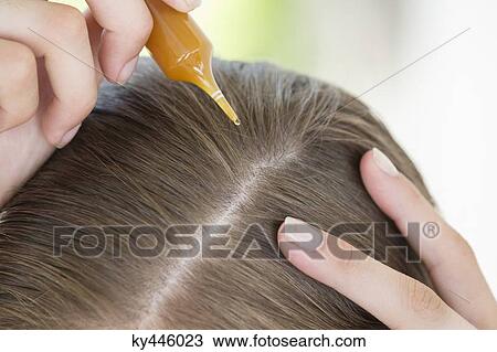 Woman pouring hair oil into her hair View Large Photo Image Stock Image - Woman pouring hair oil into her hair. Fotosearch