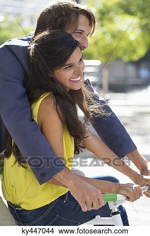 Couple riding a bicycle and smiling View Large Photo Image Picture - Couple riding a bicycle and smiling. Fotosearch