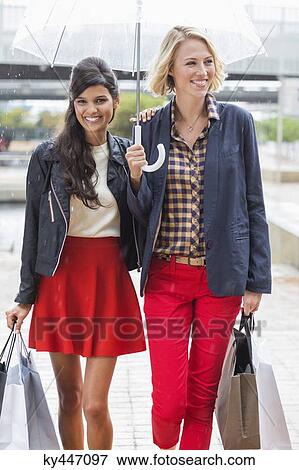 Female friends walking with shopping bags and smiling View Large Photo Image Stock Photo - Female friends walking with shopping bags and smiling. Fotosearch