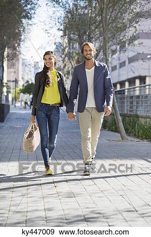 Stock Photo - Happy couple walking on a street. Fotosearch