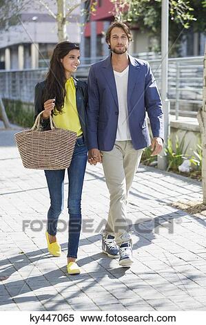 Happy couple walking on a street View Large Photo Image Stock Photography - Happy couple walking on a street. Fotosearch