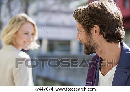 Picture - Man and woman smiling at each other. Fotosearch