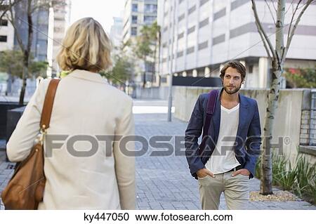 Man and woman walking on a street View Large Photo Image Stock Image - Man and woman walking on a street. Fotosearch