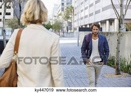 Stock Photo - Man and woman walking on a street. Fotosearch