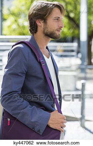 Stock Image - Man carrying a shoulder bag. Fotosearch