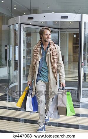 Man carrying shopping bags and smiling View Large Photo Image Stock Photo - Man carrying shopping bags and smiling. Fotosearch