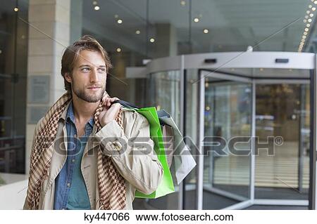 Man carrying shopping bags on his shoulders View Large Photo Image Stock Photograph - Man carrying shopping bags on his shoulders. Fotosearch