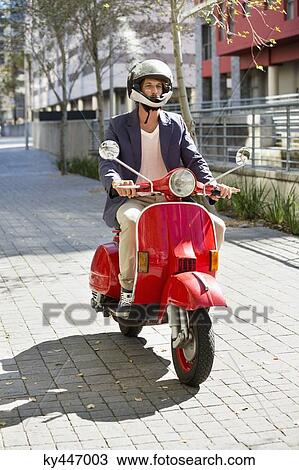 Man riding a scooter View Large Photo Image Stock Image - Man riding a scooter. Fotosearch