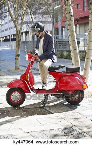Man standing with a scooter View Large Photo Image Picture - Man standing with a scooter. Fotosearch