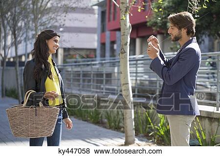 Man taking picture of his friend with a mobile phone View Large Photo Image Stock Photo - Man taking picture of his friend with a mobile phone. Fotosearch