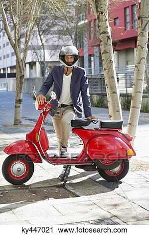 Portrait of a man standing with his scooter View Large Photo Image Stock Image - Portrait of a man standing with his scooter. Fotosearch