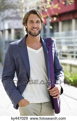 Stock Photo - Portrait of a man walking on a street and smiling. Fotosearch