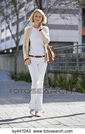 Stock Image - Portrait of a woman walking on a street. Fotosearch