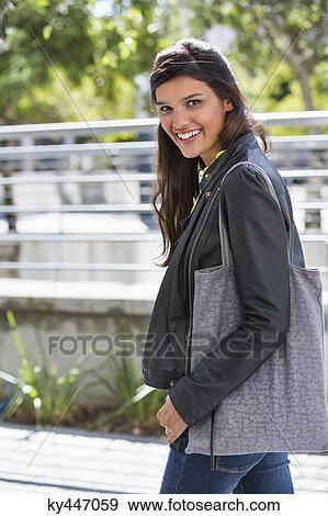 Portrait of a woman walking on a street and smiling View Large Photo Image Stock Photo - Portrait of a woman walking on a street and smiling. Fotosearch