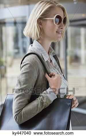 Woman carrying a handbag View Large Photo Image Stock Image - Woman carrying a handbag. Fotosearch