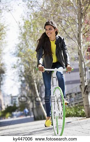 Woman riding a bicycle and smiling View Large Photo Image Stock Photograph - Woman riding a bicycle and smiling. Fotosearch