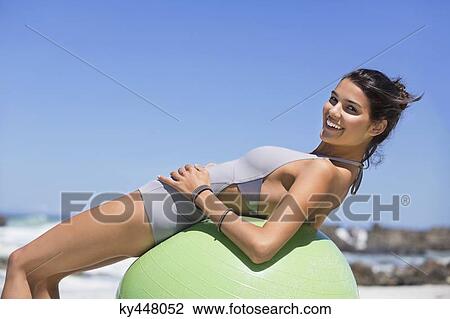 Beautiful woman exercising with fitness ball on the beach View Large Photo Image Stock Image - Beautiful woman exercising with fitness ball on the beach. Fotosearch