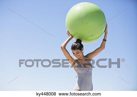 Beautiful woman holding a fitness ball on the beach View Large Photo Image Stock Photo - Beautiful woman holding a fitness ball on the beach. Fotosearch