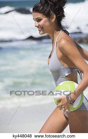 Beautiful woman holding a volleyball on the beach View Large Photo Image Stock Photo - Beautiful woman holding a volleyball on the beach. Fotosearch
