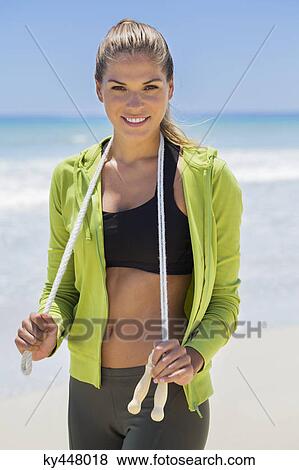 Portrait of a woman holding a skipping rope View Large Photo Image Stock Photo - Portrait of a woman holding a skipping rope. Fotosearch