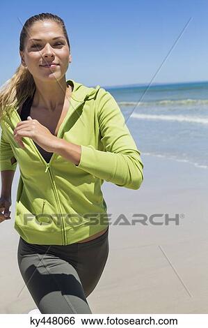 Stock Photograph - Portrait of a woman running on the beach. Fotosearch