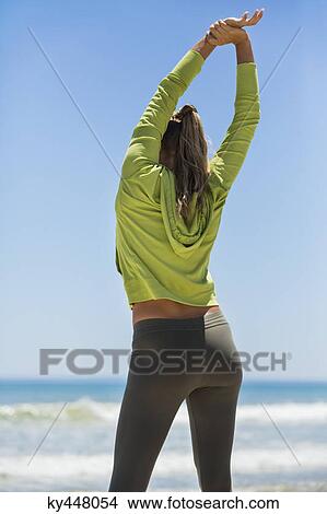 Rear view of a woman exercising on the beach View Large Photo Image Picture - Rear view of a woman exercising on the beach. Fotosearch